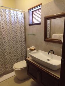 ein Badezimmer mit einem Waschbecken, einem WC und einem Spiegel in der Unterkunft Hotel Plaza Copan in Ruinas de Copán