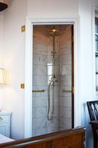 a shower in a room with a white wall at The West Usk Lighthouse Lightkeepers Lodge in Newport