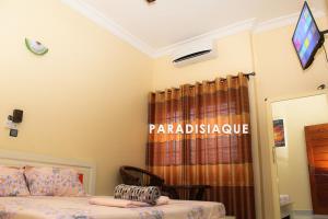 um quarto com uma cama e uma janela com uma cortina em PARADISIAQUE em Cotonou