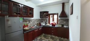 a kitchen with wooden cabinets and a white refrigerator at Sun Kiss lagoon bentota in Bentota