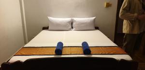 - un lit dans une chambre avec des chaussures bleues dans l'établissement Smiley's Guesthouse, à Siem Reap