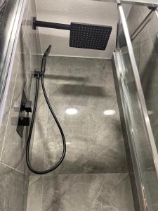 a shower in a bathroom with a hose at Da Vinci Guest House & Guest Parking in Crawley