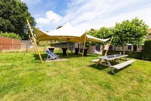 a picnic table and a tent in the grass at VET - Bed & Breakfast in Beek