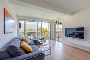 un soggiorno con divano e grande TV di Sasso Boretto, Luxury Holiday Apartments ad Ascona