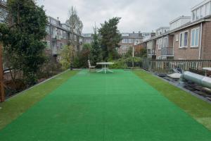 um relvado artificial verde num quintal com edifícios em The Diem Amsterdam em Amesterdão