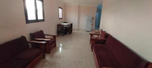 a waiting room with couches and tables and chairs at Al Haweej in Marsa Matruh