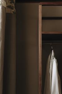 a closet with a wooden rack with a white shirt at Parkhotel Mondschein, a Member of Design Hotels in Bolzano