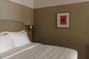 a bedroom with a bed and a picture on the wall at Parkhotel Mondschein, a Member of Design Hotels in Bolzano