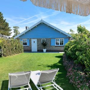 a blue house with two chairs in the yard at Casa Pueblo Viejo in Ouddorp