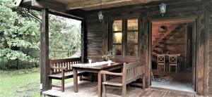 une cabine en bois avec une table et des chaises sur une terrasse dans l'établissement Ostoja Krasne, à Uścimów
