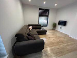 uma sala de estar com um sofá e uma televisão em Apartament w Centrum em Sokólka