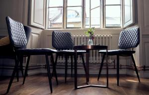 een tafel en stoelen in een kamer met een raam bij The Ollerod in Beaminster