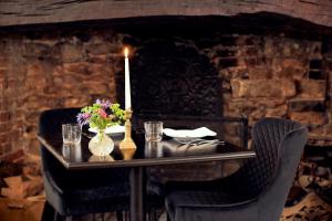 a table with a candle and flowers on it at The Ollerod in Beaminster