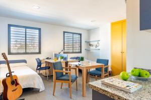 een kamer met een bed en een tafel met een gitaar bij Micampus Estanislao del Campo, Student Residence in Sevilla