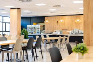 a restaurant with tables and chairs and a counter at Micampus Estanislao del Campo, Student Residence in Seville