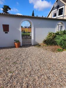a white house with a gate on the side of it at Ferienwohnung Daliah in Wangels +10 photos