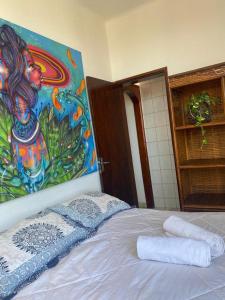 1 dormitorio con 1 cama con una pintura en la pared en Salvador Dance-Hall Cuartos Privados, en Salvador