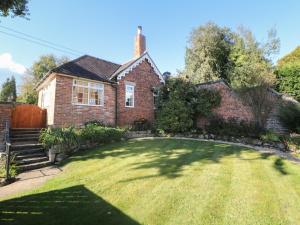 a house with a large lawn in front of it at Orchard Cottage in Ashbourne