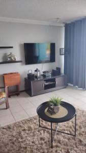 a living room with a tv and a table at Marina Lanais Condominio in Las Croabas