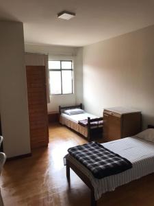 a large room with two beds and a window at Hotel São José in Ponta Grossa