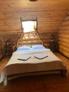 a bedroom with a bed in a log cabin at Gostynna sadyba Kit Bayun in Teterivka