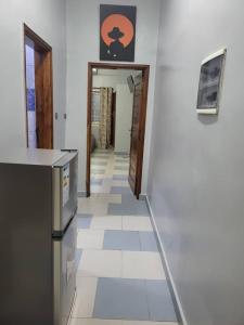 - un couloir d'une cuisine avec un comptoir et un réfrigérateur dans l'établissement MERRY LAND, à Cotonou