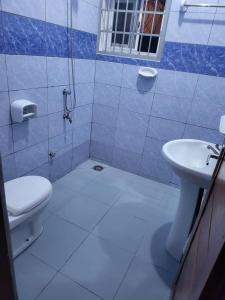 La salle de bains est pourvue de toilettes et d'un lavabo. dans l'établissement MERRY LAND, à Cotonou