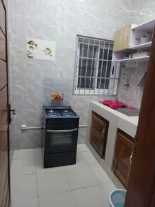 Il comprend une petite cuisine équipée d'une cuisinière et d'un évier. dans l'établissement MERRY LAND, à Cotonou