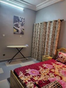 - une chambre avec un lit et une table dans l'établissement MERRY LAND, à Cotonou