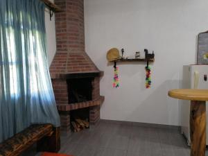 sala de estar con chimenea de ladrillo y mesa en Finca la Mariposa, Santa Elena, en Santa Elena