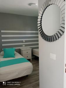 a bedroom with a bed and a mirror on the wall at Apartamentos Australia in Playa del Ingles