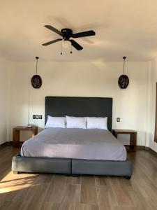 1 dormitorio con 1 cama y ventilador de techo en Mar De Estrellas - Hotel en Costa Esmeralda