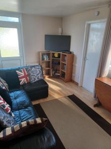 a living room with a couch and a flat screen tv at 2-bedroom Holiday Home With Great Outdoor Space in Kidwelly