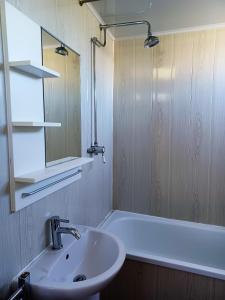 a bathroom with a sink and a tub and a mirror at 2-bedroom Holiday Home With Great Outdoor Space in Kidwelly