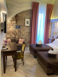 ein Hotelzimmer mit einem Bett, einem Sofa und einem Tisch in der Unterkunft Lo Scoglio dei Volsci in Nettuno