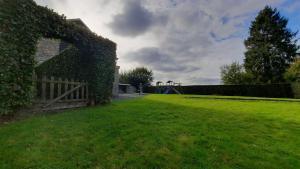een grasveld met een hek en een speeltuin bij Les 12 bois du cerf in Tailles