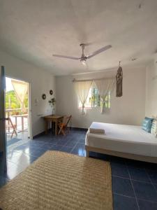 a bedroom with a bed and a dining room with a table at Barco Verde Hostel in Holbox Island