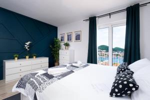 a bedroom with a white bed and a large window at Villa Gaga in Dubrovnik