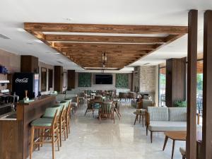 un ristorante con bar, tavoli e sedie di Pinhan Otel Kazdağıları a Ayvacık