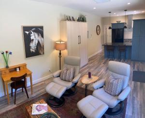 a living room with two chairs and a table at Hardy’s Haven in North Saanich