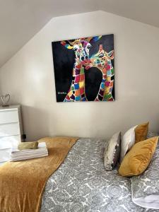 una camera da letto con un letto e un dipinto sul muro di The Shed . A cosy, peaceful, 96% recycled, chalet. a Swansea
