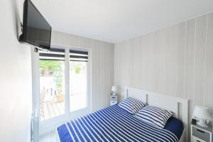 sypialnia z łóżkiem, telewizorem i oknem w obiekcie L appart de Villers HYPER centre WI-FI Parking w mieście Villers-sur-Mer