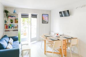 salon ze stołem i niebieską kanapą w obiekcie L appart de Villers HYPER centre WI-FI Parking w mieście Villers-sur-Mer