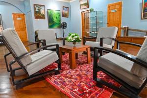 a living room with chairs and a table and a rug at Traum House in Saint Augustine +2 photos