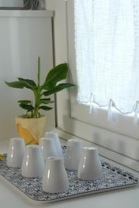 un vassoio con tazze bianche e una pianta in vaso di Da Irene a Mestre