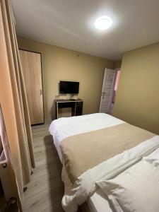 a bedroom with two beds and a desk with a television at Gostynna sadyba Kit Bayun in Teterivka