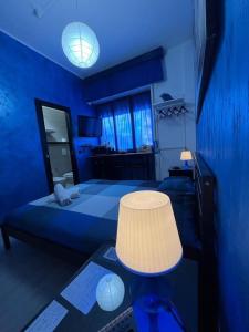 um quarto azul com uma cama e uma mesa com um candeeiro em Light Home em Avellino