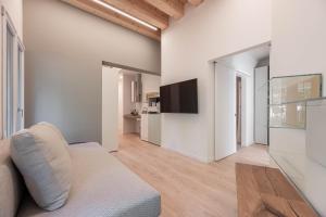 Palazzo '900 Design Flats - L'Orologiaio في بادوفا: غرفة معيشة مع أريكة وتلفزيون