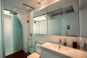 bagno con lavandino, servizi igienici e specchio di Casa di Vito a Mykonos Città