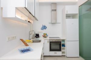 una cucina bianca con lavandino e frigorifero di Casa di Vito a Mykonos Città
